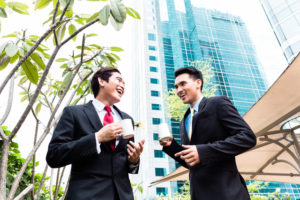 Asian businesspeople drinking coffee outside